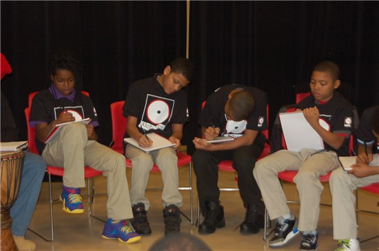 The newest cohort of sixth graders jot down their thoughts in journals at Crouse Community Learning Center